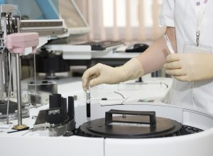 技术人员在电脑前检查服务器监控面板，屏幕显示多项系统运行指标